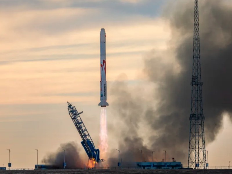 The white and red Zhuque-2E Y1 rocket launch by Landspace on November 27, 2024, against a morning sky, with an exhaust plume and smoke billowing as the rocket ascends.